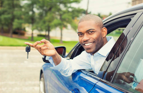 Man in a car holding a car key